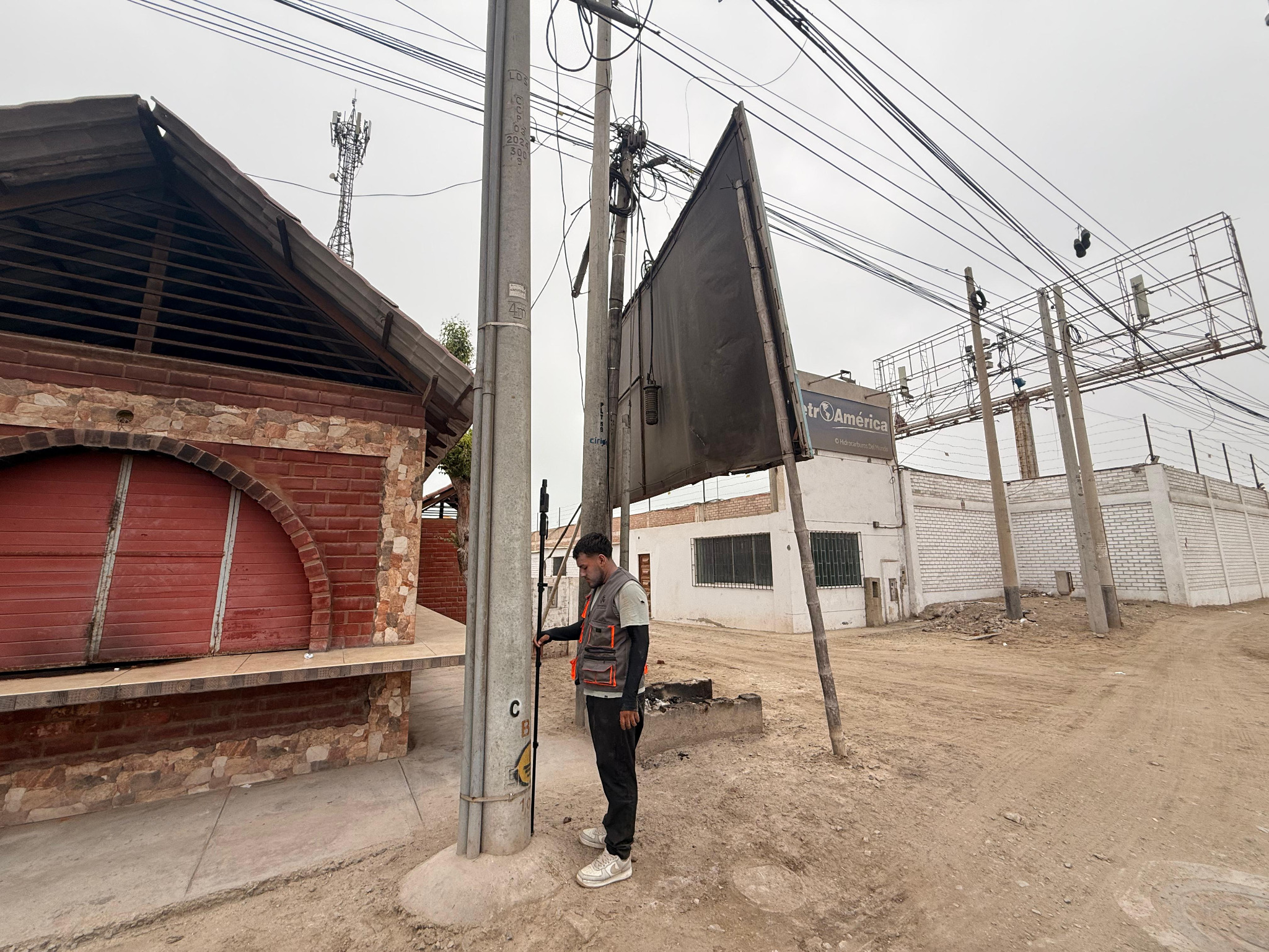Surveyor measuring near a utility pole with GNSS receiver